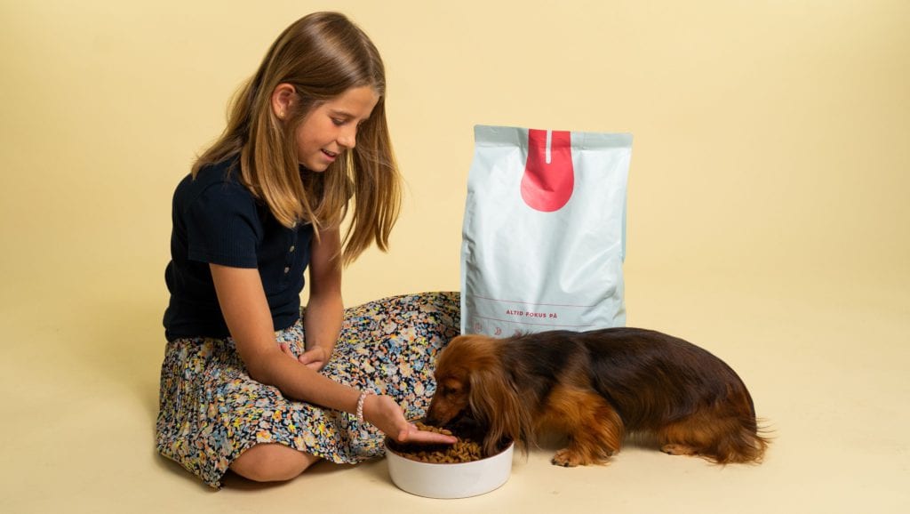 pige giver foder til hundVuffeli hundeblog
